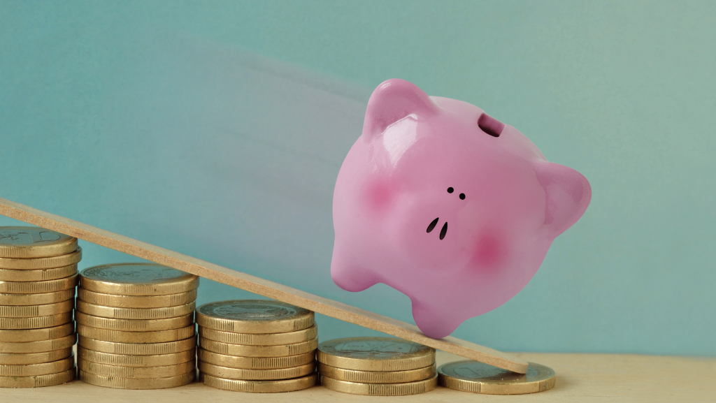Avoid Losing Money: 5 Facts About Diminished Value Claims in Georgia Pink piggy bank sliding down a ramp made of coins, symbolizing lost vehicle value and diminished value claims in Georgia after a car accident.
