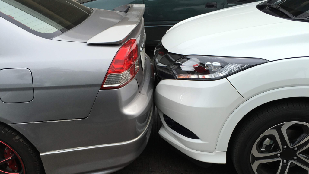 Close-up of a rear-end car collision between a silver sedan and a white SUV