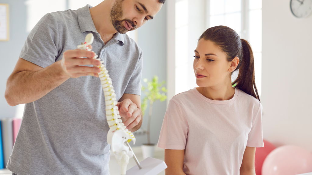 Chiropractor showing spine model to patient during first chiropractic visit after car accident in Georgia